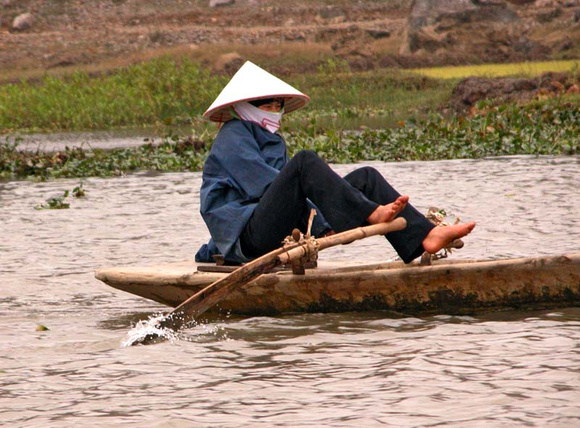 Locals row boats by foot