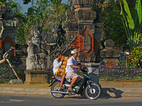 A common sight: offerings, bikes, sarongs, statuary